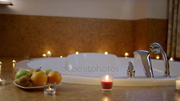Vatten som rinner i badet och plattan med frukter stående nära — Stockvideo