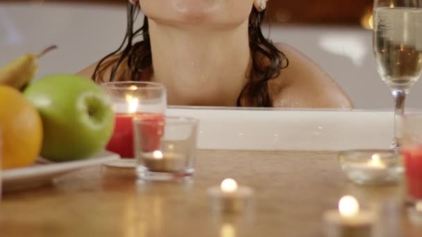 Cámara lenta de una chica soplando beso a cámara sentado en el baño — Vídeos de Stock