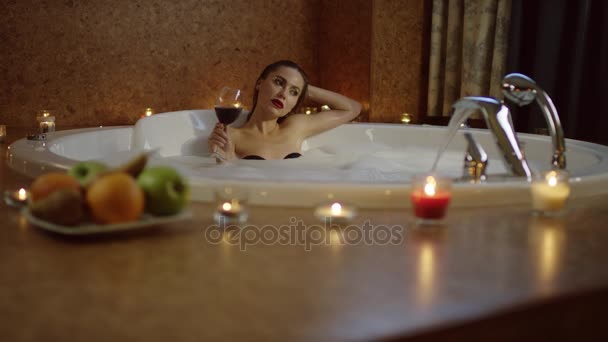 Kvinna med glas rött vin i badet med skum — Stockvideo