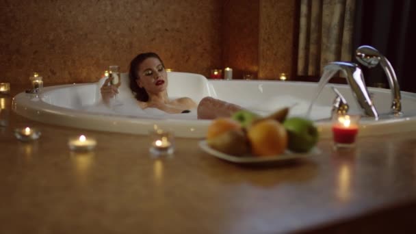 Frau nimmt Schluck Champagner im Bad mit Schaum und entspannen — Stockvideo