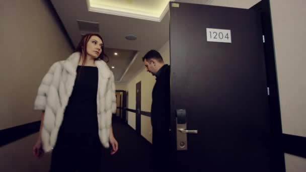 Couple coming from room and calling elevator with handbag — Stock Video