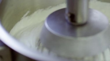 Elektrikli karıştırıcı makine tarafından metal kapta krem kırbaçlanan