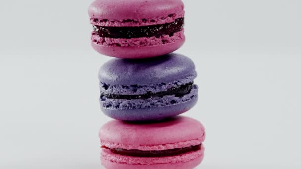 Three colourful macarons, which lay on each other, are rotating before the camera — Stock Video
