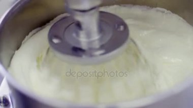 Elektrikli karıştırıcı makine ile metal kapta krem kırbaçlanan