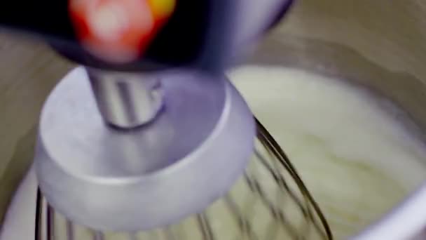 Fouetter la crème dans un bol métallique avec mélangeur électrique 