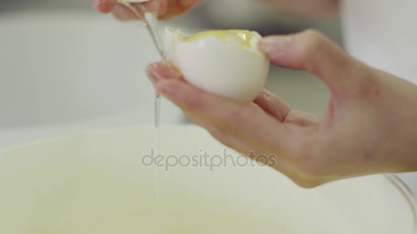 Ženská ruka přestávky vejce a oddělit žloutek od proteinu — Stock video