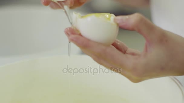 Mão feminina quebra ovo e separa a gema da proteína — Vídeo de Stock