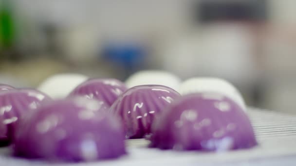Weiße Kuchen sind mit violetter Glasur überzogen — Stockvideo