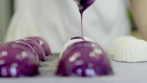 Процесс покрытия тортов фиолетовой глазурью — стоковое видео