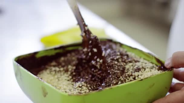 Смешивание расплавленного шоколада и молотых орехов — стоковое видео