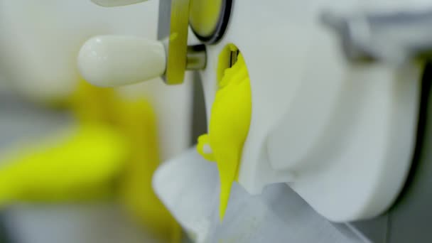 Machine spills yellow ice-cream close up view — Stock Video