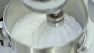 Elektrikli karıştırıcı makine ile metal kapta krem kırbaçlanan