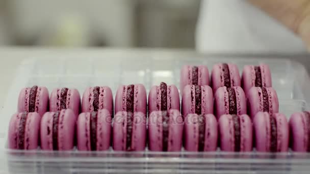Emberi kéz csomag rózsaszín macarons — Stock videók