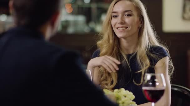 Beautiful blondie telling to partner in restaurant — Stock Video