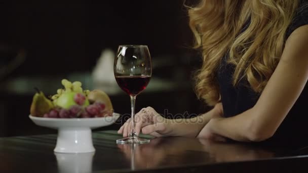 Lonely lady touching a glass of red wine in cafe — Stock Video