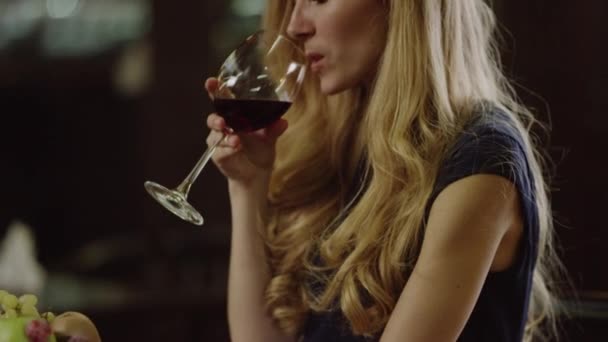 Blondie vrouw drinken van rode wijn in café — Stockvideo
