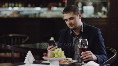 restoranda oturan smartphone ile yakışıklı adam
