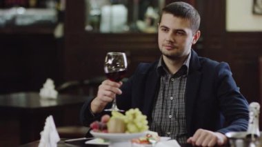 Restoranda yalnız kırmızı şarap içme genç adam