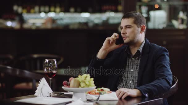 Jovem falando no celular no restaurante — Vídeo de Stock