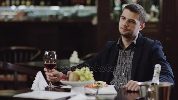 Человек пьет красное вино в кафе — стоковое видео