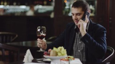 Telefonla konuşurken ve restoranda şarap içmek işadamı
