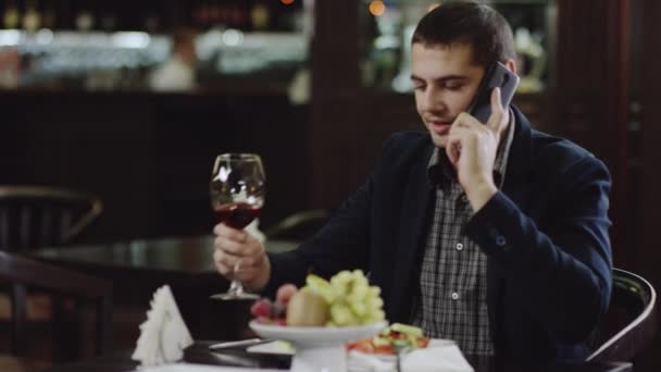 Uomo d'affari che parla per telefono e beve vino al ristorante — Video Stock