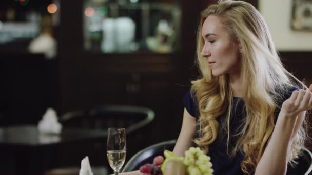 Blondie mávat na člověka v restauraci z jiného místa — Stock video
