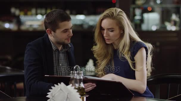 Пара вирішує страву на вибір в кафе — стокове відео