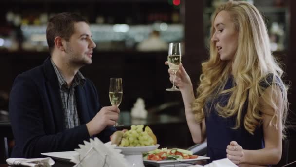 Романтична пара вітає з шампанським у кафе — стокове відео