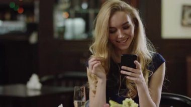 restoranda oturan smartphone ile güzel kadın