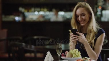 smartphone kafede oturan güzel sarışın kadınla