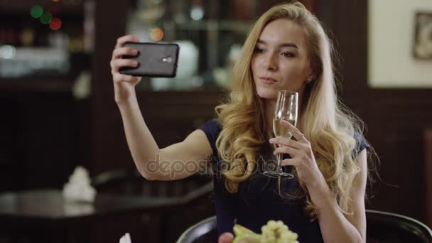 Attrayant jeune femme prendre un selfie dans un restaurant chic — Video