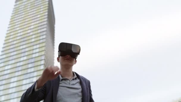 Kaukasiska man använder Virtual Reality-glasögon flytta händerna — Stockvideo