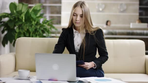 Mujer de negocios que trabaja con el ordenador portátil y documentos — Vídeo de stock