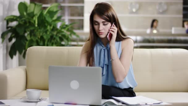 Femme d'affaires sur ordinateur portable et téléphone portable dans occupé — Video