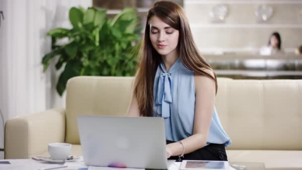 Attractive woman tourist enjoying the laptop in the hotel lobby — Stock Video