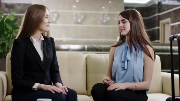 Dois amigos sorridentes conversando um com o outro no lobby — Vídeo de Stock