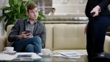 kadın ve lobide onların akıllı telefonlar kullanan adam