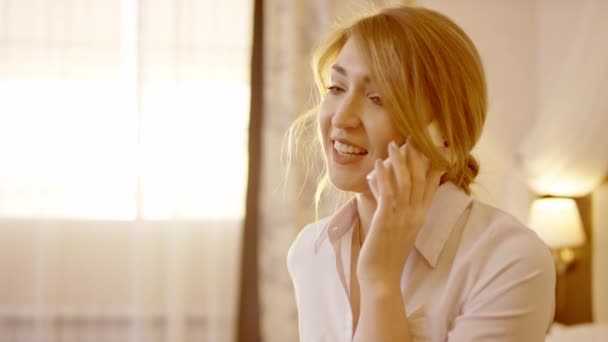 Mujer joven está hablando en el teléfono inteligente y sonriendo — Vídeos de Stock