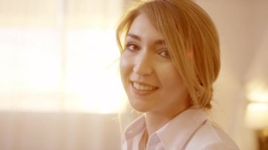 Kafa dönme ve kameraya gülümseyen genç güzel sarışın kadın