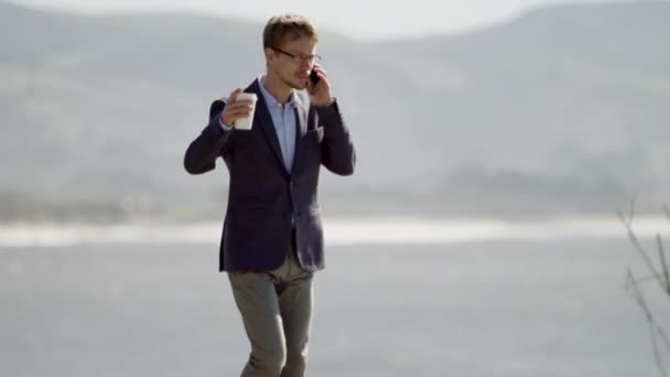 Giovane uomo d'affari che cammina lungo la costa dell'oceano Pacifico — Video Stock
