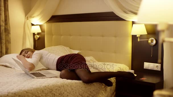 Женщина устала от работы спит на большой белой кровати — стоковое видео