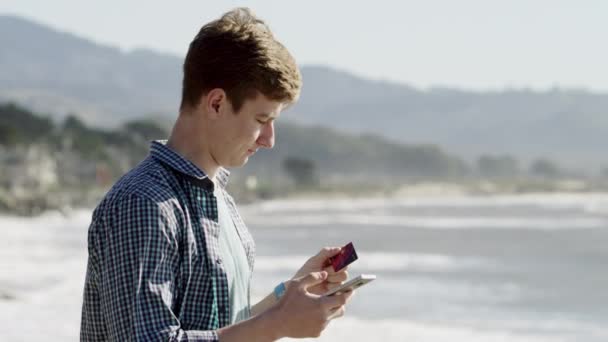 Genç adam Pasifik Okyanusu kıyısında duruyor — Stok video