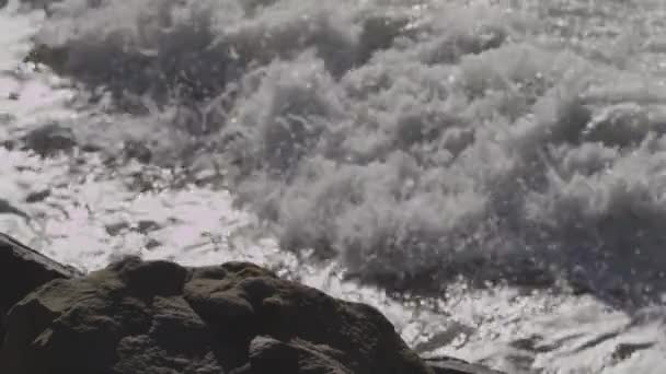 Onde oceaniche si infrangono su una spiaggia e scogliere rocciose — Video Stock