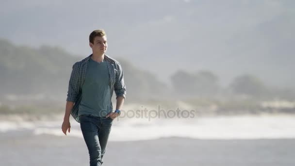 Joven caminando a lo largo de la costa del océano Pacífico — Vídeos de Stock