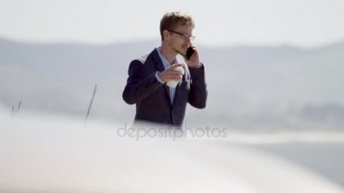 Genç işadamı Pasifik Okyanusu kıyısında yürüyüş