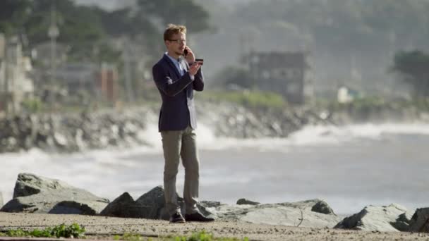 Jonge zakenman staat aan de kust van de Stille Oceaan — Stockvideo