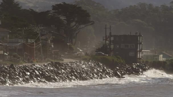 Океанские волны врезаются в пляж и скалистые скалы — стоковое видео