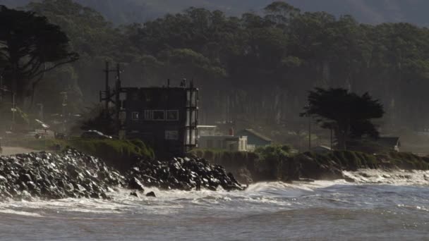 Океанские волны врезаются в пляж и скалистые скалы — стоковое видео