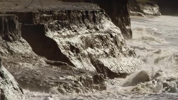 Des vagues océaniques s'écrasent sur une plage et des falaises rocheuses — Video